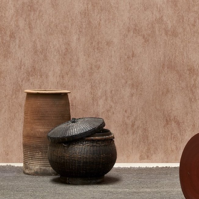 Rustiek interieur met Arte behang Manchas in aardetinten en decoratieve manden op een grijze vloer.