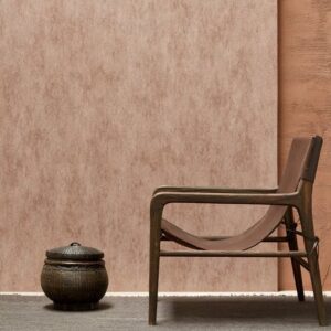 Luxe interieur met Arte behang Manchas in warme aardetinten, houten loungestoel en decoratieve mand.
