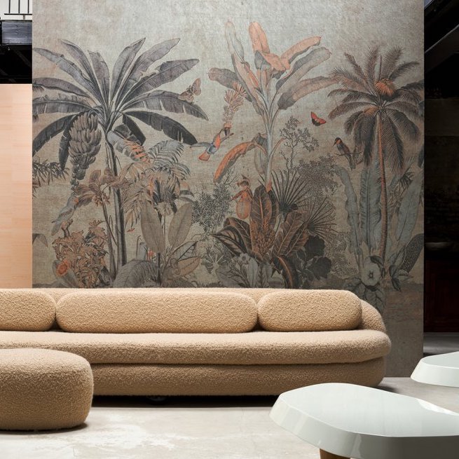 Beige designbank voor een muur met tropisch Arte-behang uit de Milk & Honey-collectie.