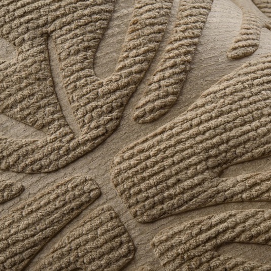 Detail van Arte Monstera behang met een reliëfstructuur van bladmotief in beige tinten.