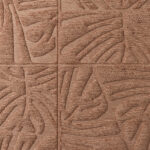 Close-up van het Arte Monstera 43023 behang met een reliëfpatroon van tropische bladeren in een warme, koperbruine tint.
