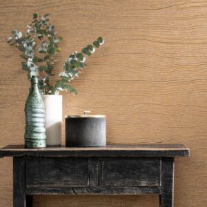 Zwart houten tafeltje met decoratieve objecten voor een muur met Arte behang Timber Copper.