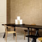 Moderne eetkamer met Arte behang Twine in een warme naturel tint en een zwart houten tafel met houten stoelen.