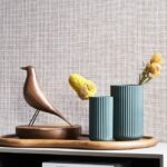 Houten vogelbeeld en geribbelde vazen met bloemen voor Arte Waffle Weave behang.
