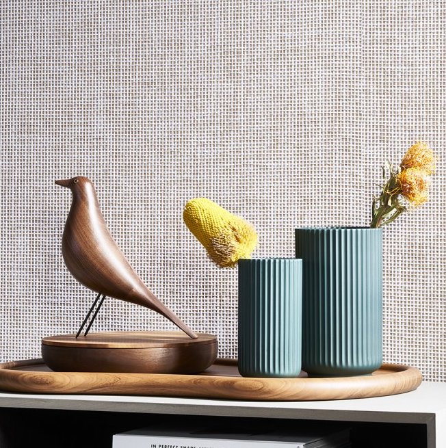 Houten vogelbeeld en geribbelde vazen met bloemen voor Arte Waffle Weave behang.