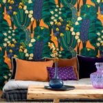 Interieur met kleurrijk Elitis Broceliande TP 322 04 behang met botanisch patroon, velvet kussens en houten salontafel.