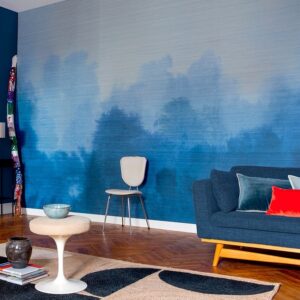 Moderne woonkamer met Elitis behang Brume VP 933 01 in blauwe tinten en een blauw bankstel.