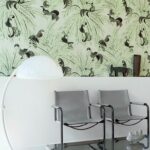 Moderne zithoek met grijs Elitis La Californie VP 923 01 behang met tropische vogels en palmbladeren.