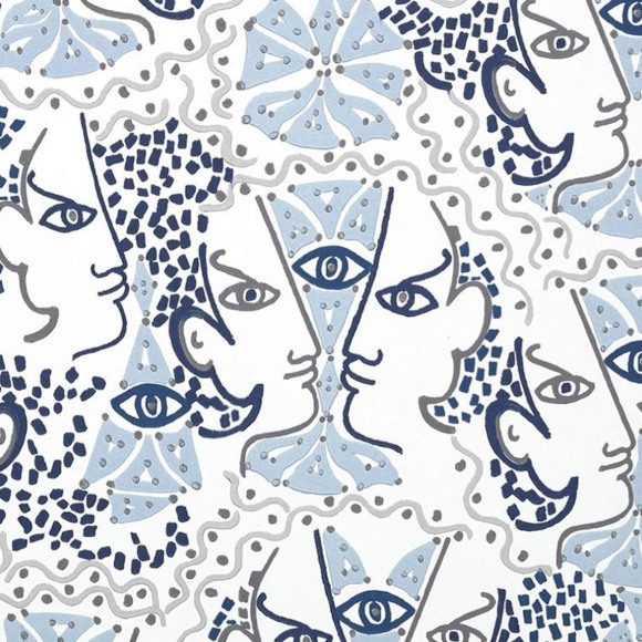 Grafisch behangpatroon van Lelievre Cocteau met gestileerde gezichten, ogen en abstracte vormen in blauw- en grijstinten.