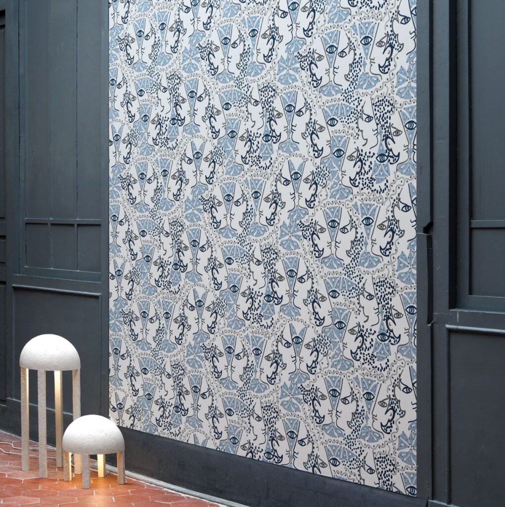 Behang met abstracte gezichten en blauwe patronen uit de Lelievre Union collectie in een moderne interieursetting.