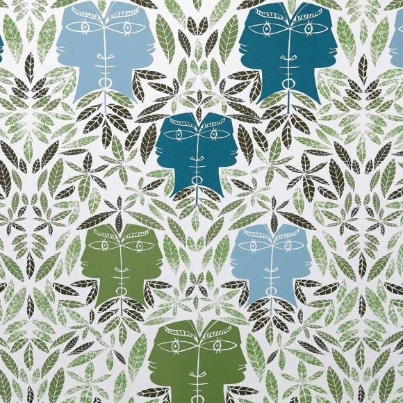 Behangpatroon Cap d'Ail van Lelievre met gestileerde gezichten in blauw- en groentinten omringd door decoratieve bladeren.