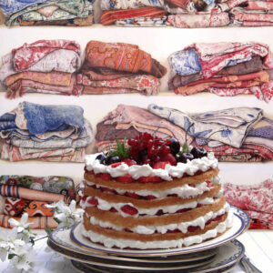 Luchtige laagjestaart met slagroom en rood fruit voor behang met kleurrijke opgestapelde stoffen uit de Pierre Frey collectie L’Armoire de Marguerite.