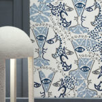 Artistiek blauw-wit behang van Behangstudio UNION met abstracte gezichten en oogmotieven.