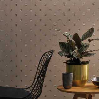 Modern interieur met CASAMANCE Apis 2-behang met bijenmotief, een plant in een gouden pot en een zwarte designstoel.