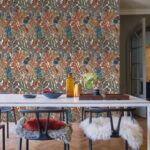 Eetkamer met kleurrijk CASAMANCE BORROMEE-behang met botanisch patroon op de achterwand.