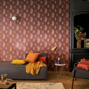 Sfeervolle woonkamer met CASAMANCE Isoete behang in warme tinten en kleurrijke accessoires.