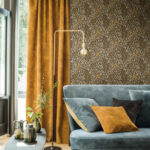 Stijlvol interieur met CASAMANCE Isoete behang, okergele gordijnen en een blauw fluwelen bank.