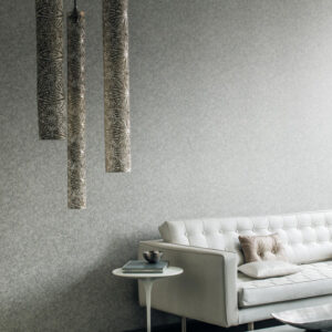 Moderne woonkamer met Dandy Faux Uni Obsessive behang, een lichte bank en stijlvolle hanglampen.