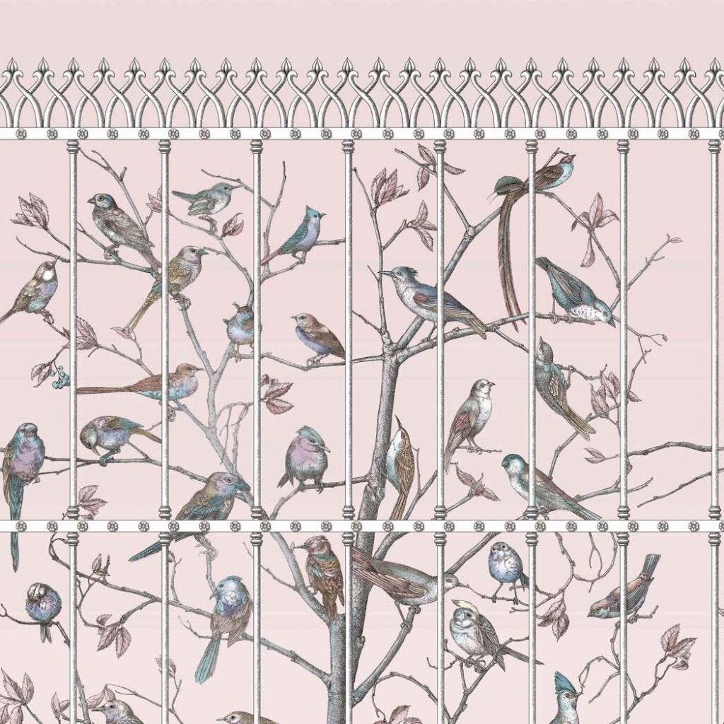 Behangontwerp Fornasetti Senza Tempo Uccelli met kleurrijke vogels op takken achter een sierlijk hekwerk.
