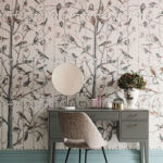 Grijze kaptafel met spiegel en decoratie staat tegen Fornasetti Uccelli behang met vogels op takken.