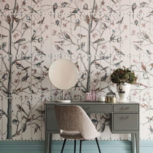 Grijze kaptafel met spiegel en decoratie staat tegen Fornasetti Uccelli behang met vogels op takken.