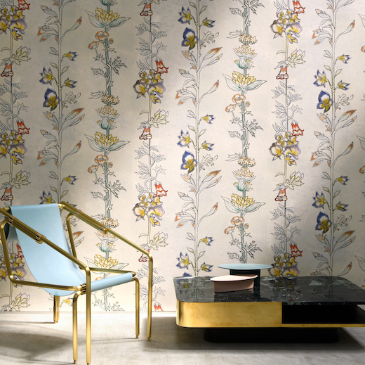 Luxe interieur met behang MILLY LA FORET met bloemmotief, een designstoel en een zwarte salontafel met gouden accenten.