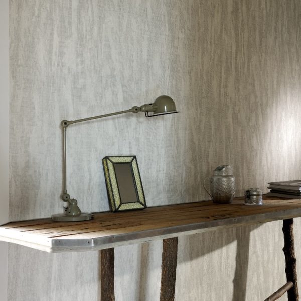 Houten tafel met industriële lamp, fotolijst en accessoires tegen een muur bekleed met Belitung-VP-723-01 behang.