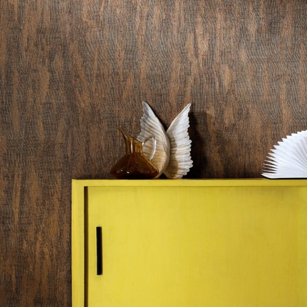Geel kastje met decoraties tegen een donkerbruine Belitung-VP-723-07 houtstructuurbehangmuur.