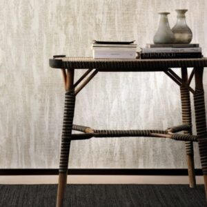 Rotan bijzettafel met boeken en aardewerken vazen tegen een muur met Belitung-VP-724-03 structuurbehang.