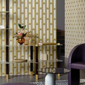 Modern interieur met Biseau Arte behang in goud en wit geometrisch patroon, gecombineerd met glazen meubels en paarse accenten.