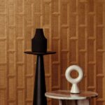 Decoratief houten wandpaneel Biseau1-GVIC-2 met geometrisch reliëfpatroon en moderne sculpturale objecten op bijzettafels.