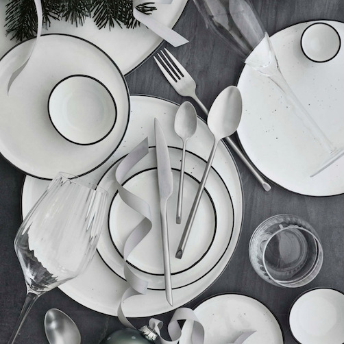 Gedekte tafel met wit servies op een grijs Broste Copenhagen linnen tafelkleed.