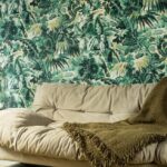 Beige bank met groene plaid voor tropisch behang met bladeren en papegaaien uit de Buningh Arte Antigua Tropicali collectie.