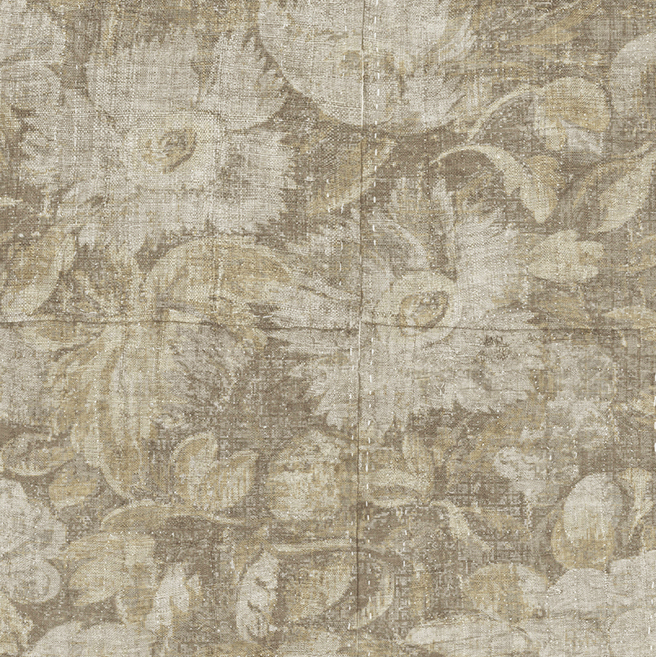 Behang uit de Natural Antigua collectie met een verweerd bloemmotief in zachte beige- en bruintinten.