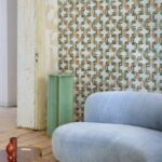 Interieur met Buningh-Arte Tatami 54520 behang, lichtblauwe bank en mintgroene zuil in een stijlvolle woonkamer.