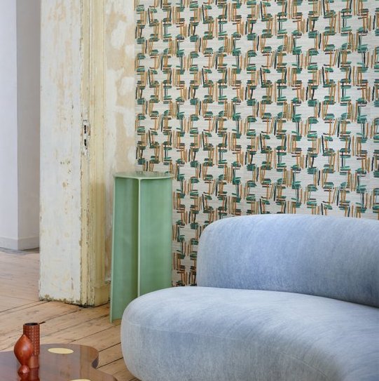 Interieur met Buningh-Arte Tatami 54520 behang, lichtblauwe bank en mintgroene zuil in een stijlvolle woonkamer.