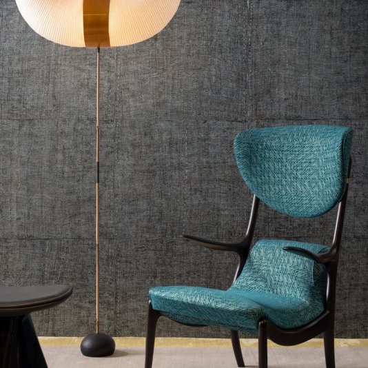 Designinterieur met Buningh-Arte Tintura 33028 behang uit de Amaranth Antigua collectie, naast een moderne stoel en staande lamp.