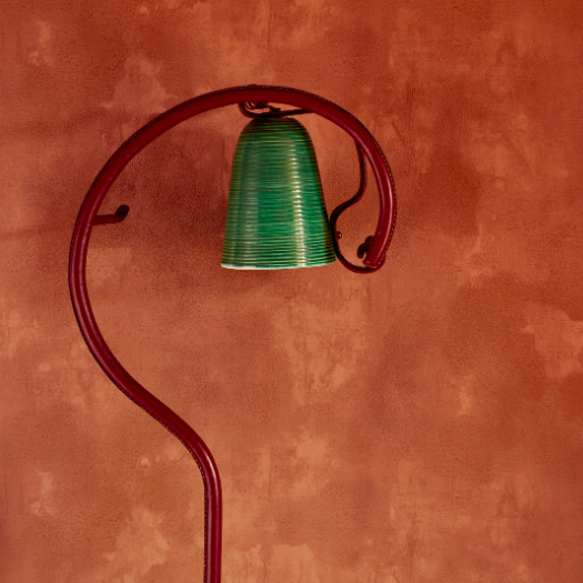 Groene lamp aan een gebogen rode standaard tegen rood Buningh-Elitis Ortigia Agrigente vp 960 behang.