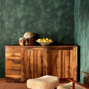 Houten dressoir tegen een donkergroene Ortigia Agrigente-behangmuur met decoratieve vazen en een schaal met fruit.