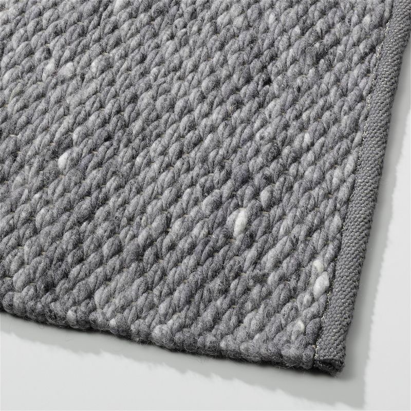 Grijs Perletta Finesse vloerkleed met grove, geweven textuur en afgebiesde rand.