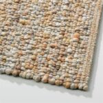 Detail van het Perletta vloerkleed Gravel 423 in de kleur honey met grove, handgeweven structuur en warme tinten.