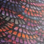 Detailopname van het Arte Moooi Dandelion Cranes behang met een kleurrijk, textuurrijk patroon in paarse, rode en oranje tinten.