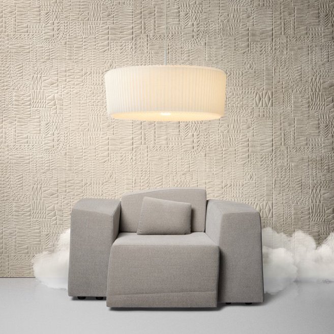 Grijze Arte Moooi PogoGoat1 fauteuil tegen een beige textuurwand met een grote hanglamp erboven.