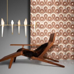 Designinterieur met een houten loungestoel, grafisch behang van Arte uit de Queen Cobra collectie, en een moderne Moooi-hanglamp.