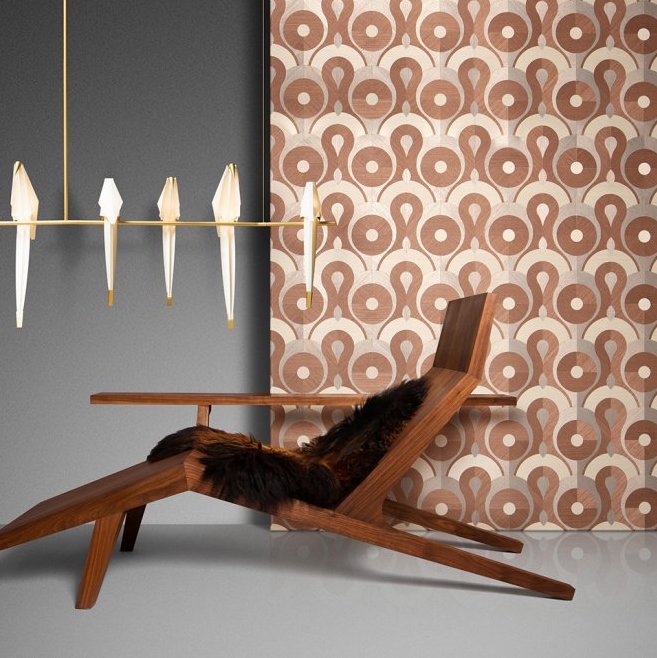 Designinterieur met een houten loungestoel, grafisch behang van Arte uit de Queen Cobra collectie, en een moderne Moooi-hanglamp.