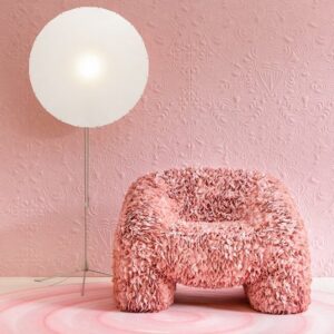 Roze designfauteuil met bloemachtig textuurontwerp van Moooi, voor een roze muur met Arte Mimic Moth behang en een grote ronde vloerlamp.
