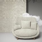 Lichtgrijze stoffen loveseat met kussens voor een muur met Arte Moooi Mimic Moth-behang in een sfeervolle setting.