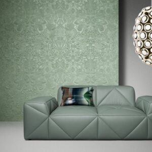 Groen Arte Moooi Mimic Moth behang met bloemenpatroon achter een moderne groene designbank en een decoratieve hanglamp.