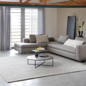 Moderne woonkamer met grijze hoekbank en Perletta Limone vloerkleed in een lichte, sfeervolle setting.