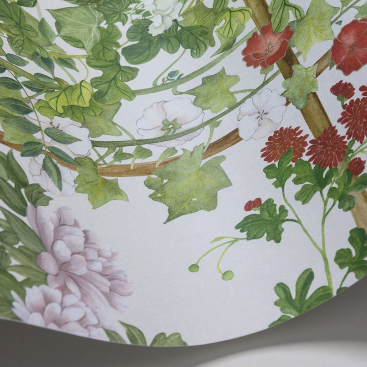 Detail van het Cole and Son Scenic Flora behang met kleurrijke bloemen, groene bladeren en klimplanten op een lichte achtergrond.